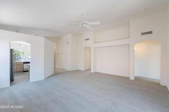 12220 N New Dawn Ave, Oro Valley, AZ 85755 - empty room featuring arched walkways, a ceiling fan, and light carpet
