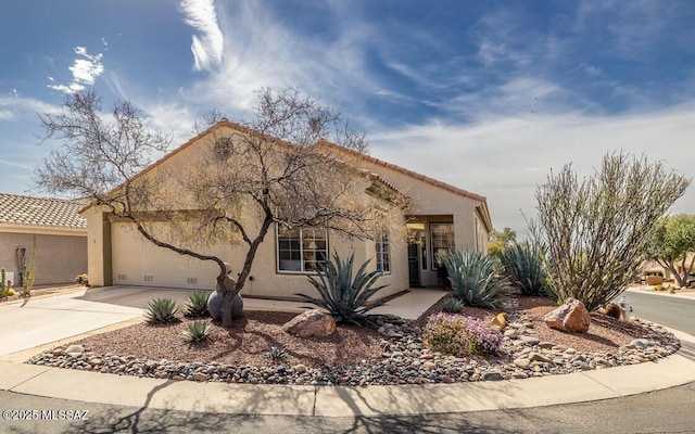 view of front of property featuring a garage, a tile roof, driveway, and stucco siding