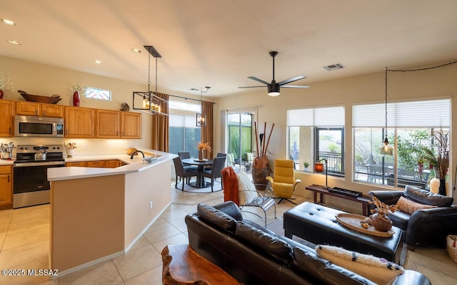 kitchen with visible vents, open floor plan, stainless steel appliances, light countertops, and light tile patterned flooring