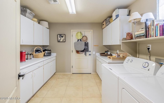 laundry room featuring visible vents, washer and clothes dryer, light tile patterned flooring, and cabinet space