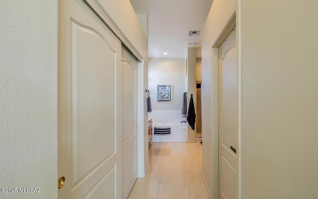 corridor featuring visible vents and light tile patterned flooring