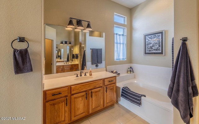 bathroom featuring a garden tub, vanity, and tile patterned floors