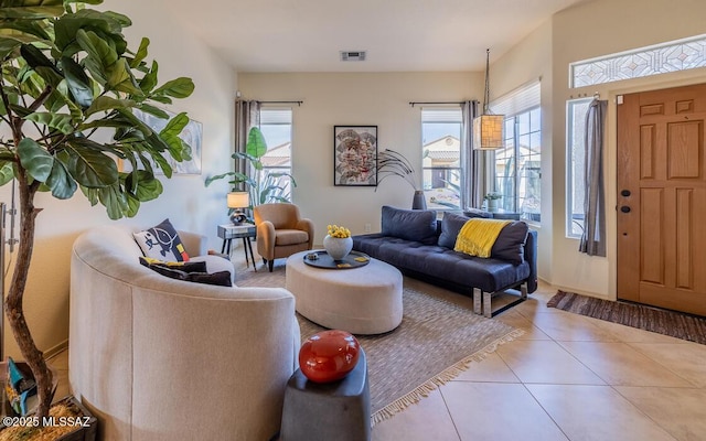 living room with light tile patterned floors, visible vents, and a healthy amount of sunlight