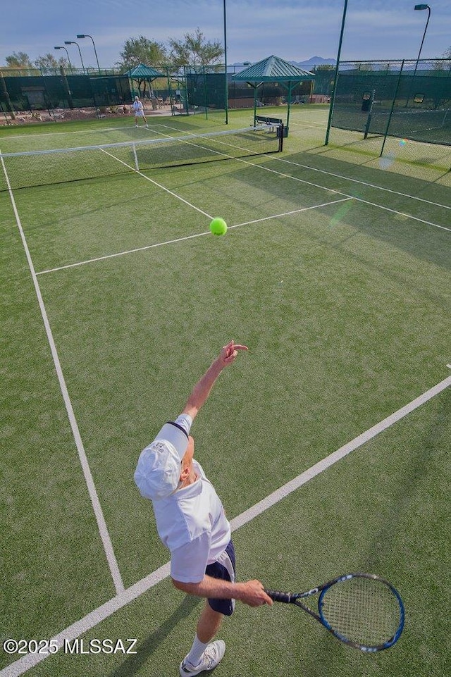 view of sport court featuring fence