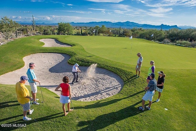 view of community featuring view of golf course and a mountain view