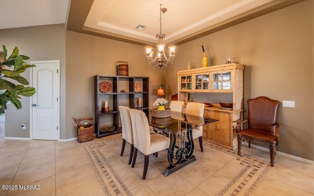 dining room featuring baseboards, visible vents, a raised ceiling, a chandelier, and light tile patterned flooring