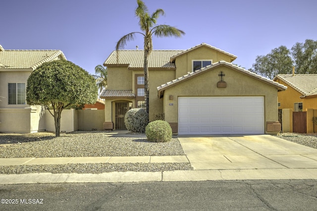 mediterranean / spanish home featuring fence, driveway, stucco siding, a garage, and a tiled roof