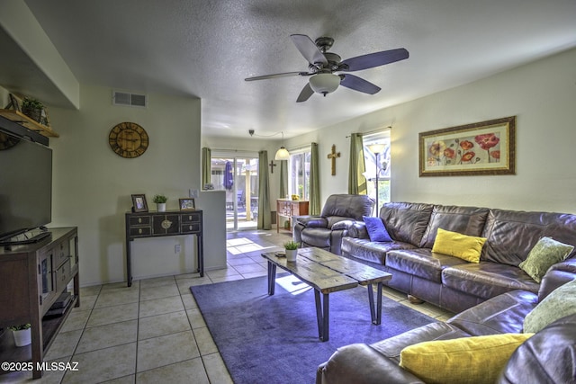 living room featuring tile patterned flooring, a ceiling fan, and arched walkways