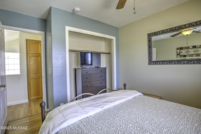 bedroom featuring wood finished floors, a closet, baseboards, and ceiling fan