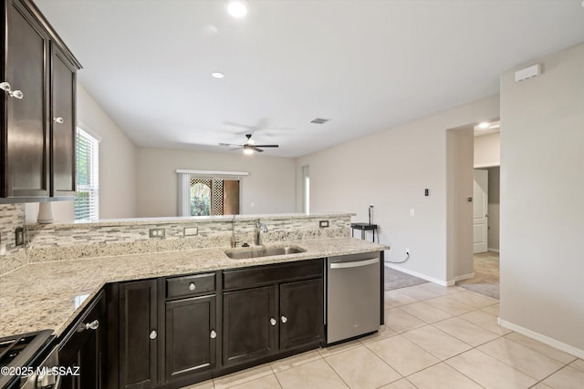 kitchen featuring visible vents, a sink, stainless steel appliances, a peninsula, and light stone countertops