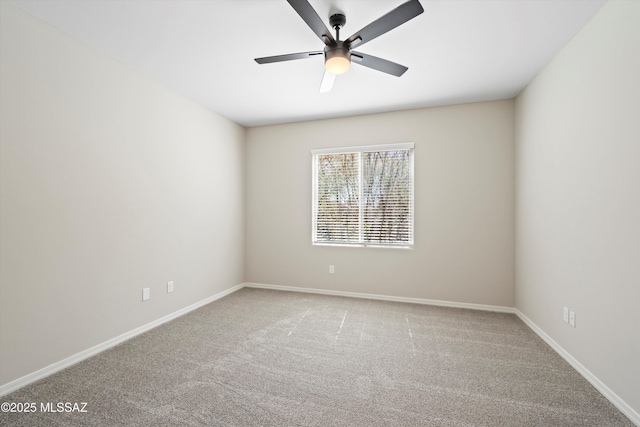 carpeted empty room with a ceiling fan and baseboards