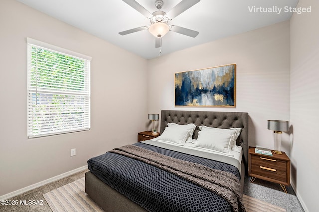 carpeted bedroom with ceiling fan and baseboards