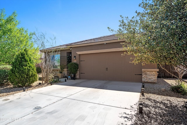 view of front facade featuring stucco siding, stone siding, driveway, and fence