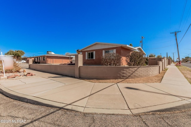 view of front of property featuring brick siding and a fenced front yard