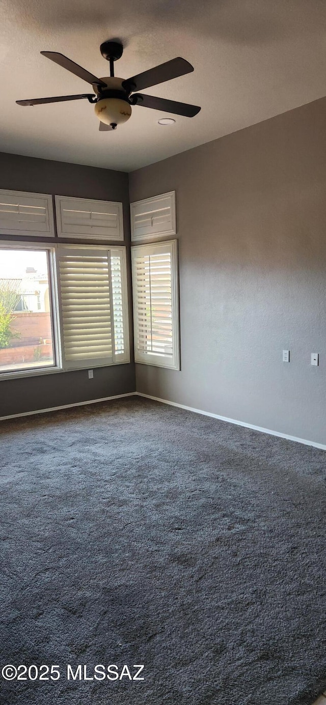 unfurnished room with carpet floors, a ceiling fan, and baseboards