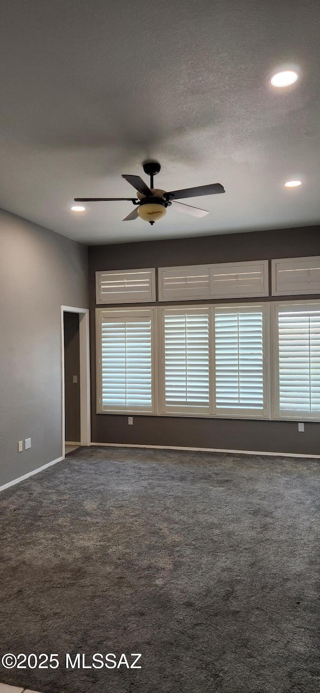 carpeted empty room with ceiling fan, baseboards, and a textured ceiling