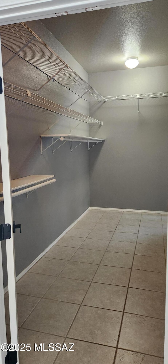 spacious closet with tile patterned floors