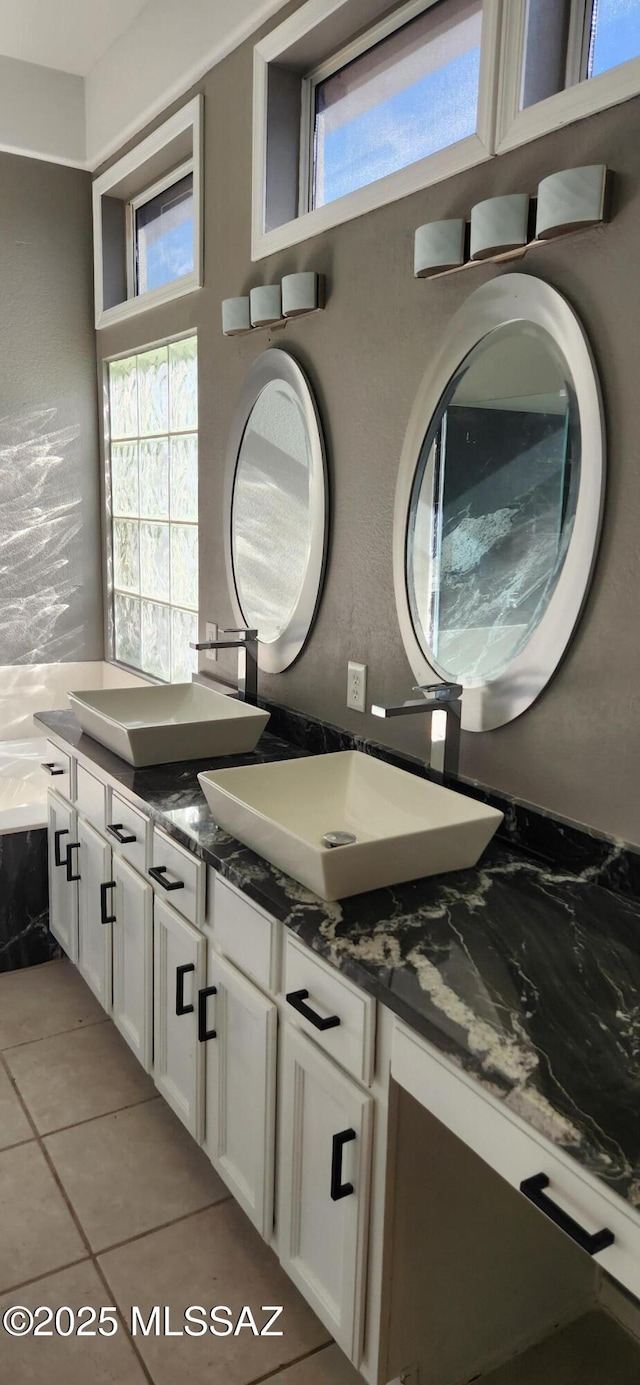 bathroom featuring a bathing tub, tile patterned flooring, a wealth of natural light, and vanity