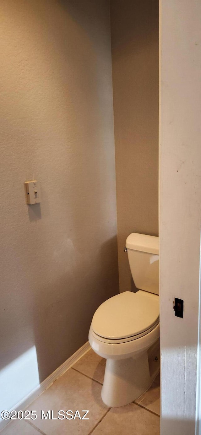 bathroom featuring baseboards, toilet, and tile patterned floors