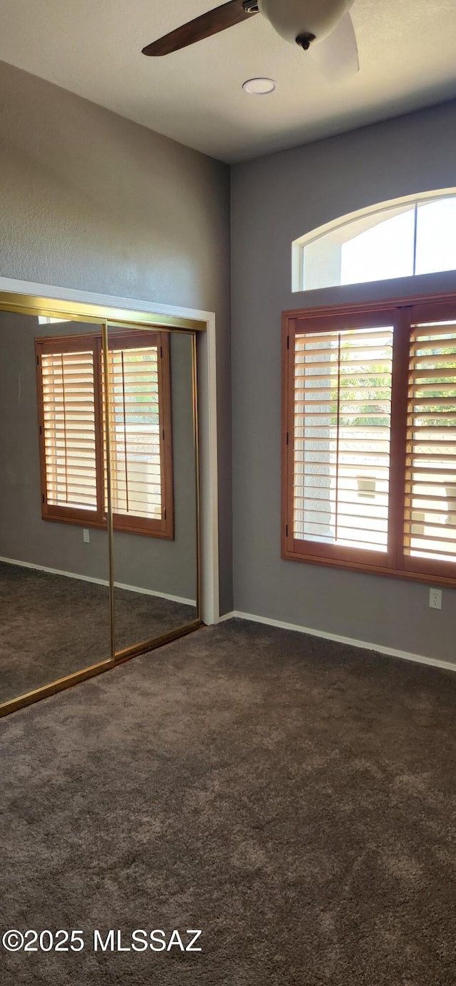 empty room with a ceiling fan, carpet, and plenty of natural light