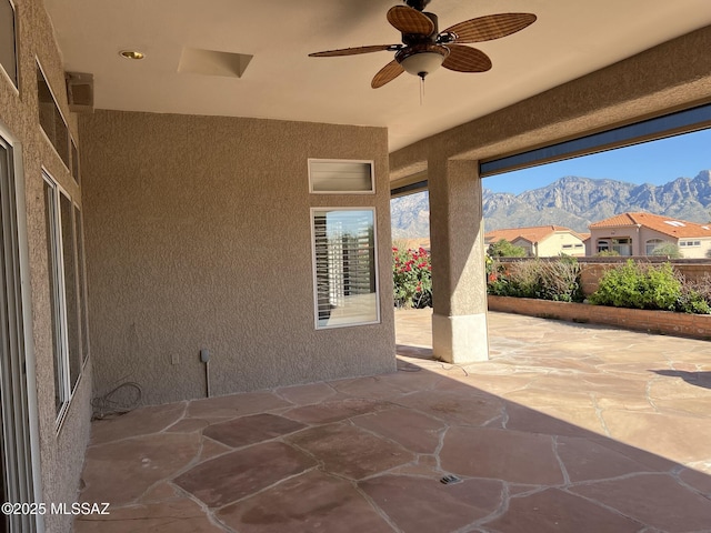 view of patio featuring ceiling fan and a mountain view