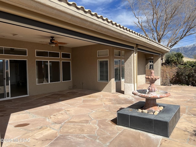 view of patio featuring a ceiling fan and a mountain view