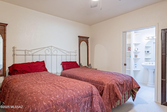 carpeted bedroom featuring ensuite bath, a ceiling fan, and a sink