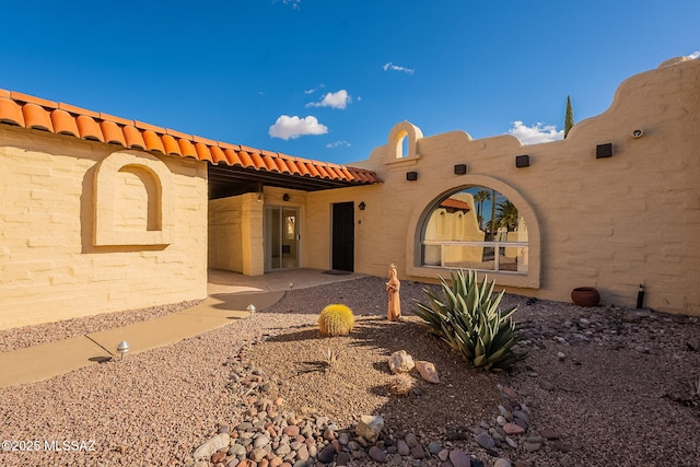 exterior space with a tiled roof and a patio