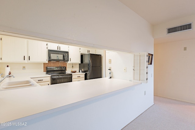 kitchen featuring light countertops, visible vents, light carpet, a sink, and black appliances