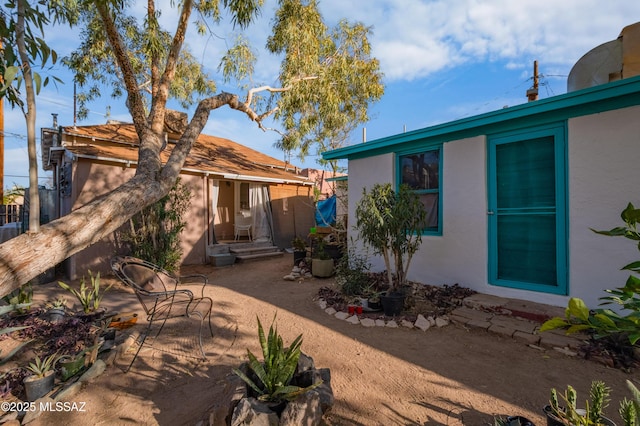 rear view of property featuring a patio area and stucco siding