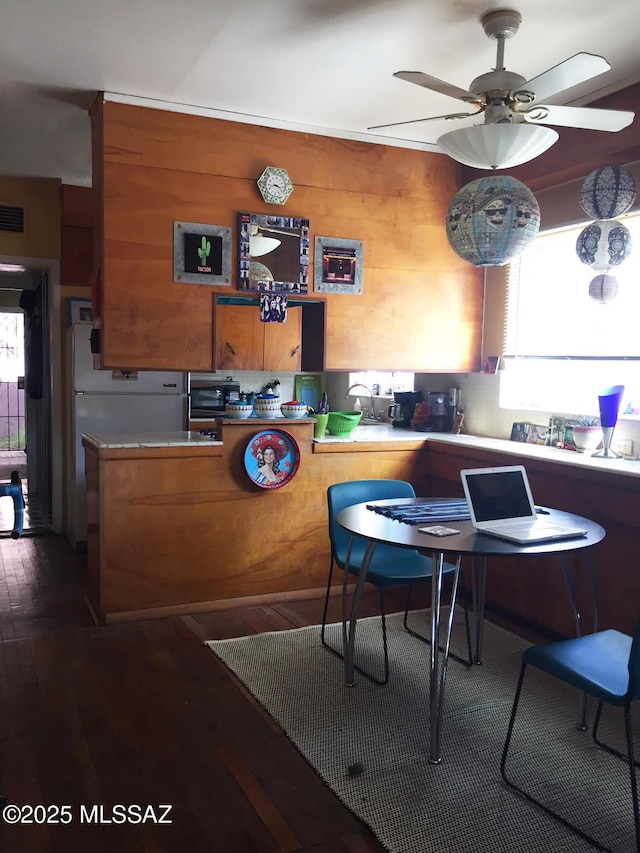 dining space featuring dark wood-style floors, visible vents, and ceiling fan