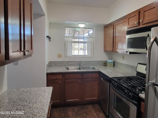 kitchen with dark wood finished floors, stainless steel appliances, and a sink