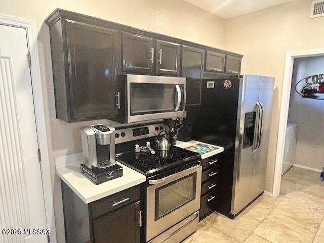 kitchen with stainless steel appliances, baseboards, visible vents, and light countertops