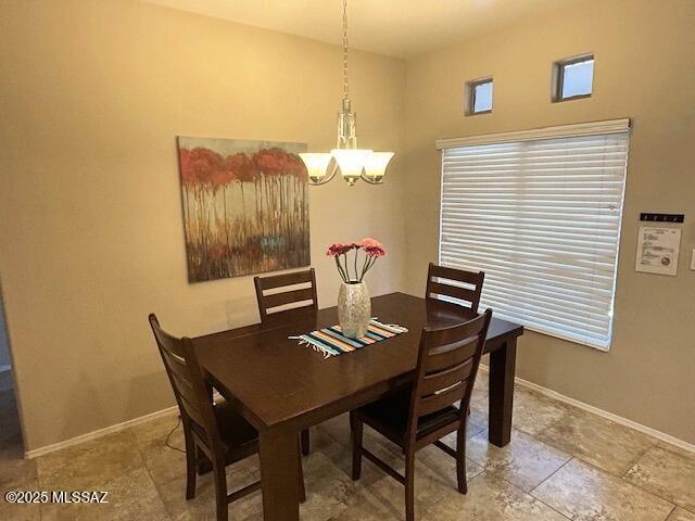 dining room featuring baseboards and a notable chandelier