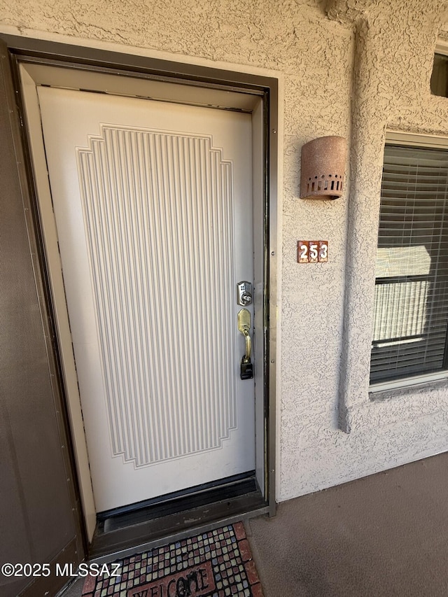 doorway to property with stucco siding