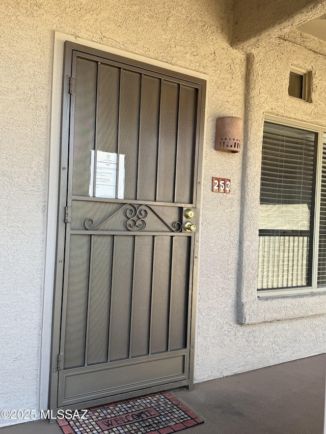 entrance to property featuring stucco siding