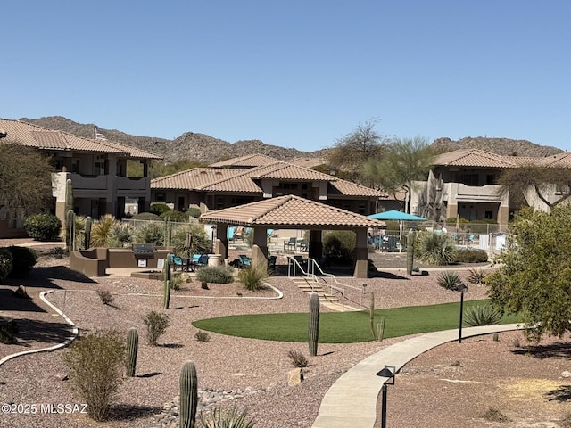 view of community featuring a gazebo, a mountain view, a residential view, and fence