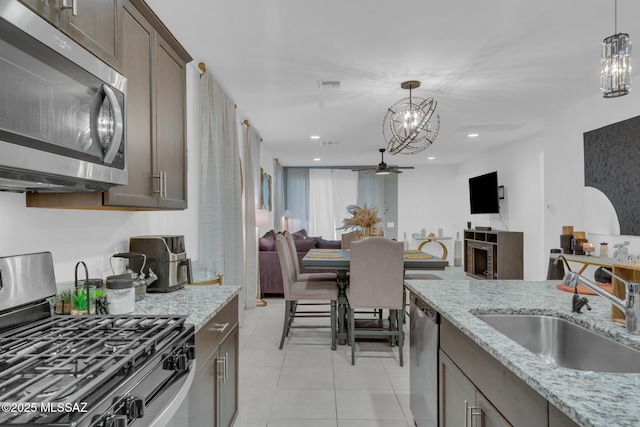kitchen with visible vents, dark brown cabinetry, pendant lighting, stainless steel appliances, and a sink