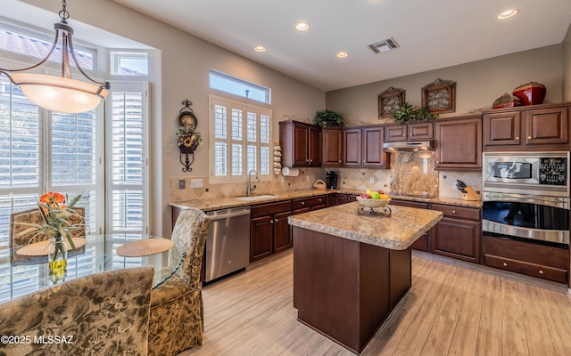 5084 W Desert Poppy Ln, Marana, AZ 85658 - kitchen featuring decorative backsplash, visible vents, stainless steel appliances, under cabinet range hood, and a sink