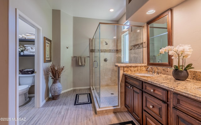 5084 W Desert Poppy Ln, Marana, AZ 85658 - full bath featuring toilet, vanity, a shower stall, wood finished floors, and baseboards