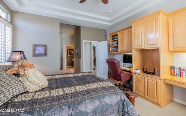 5084 W Desert Poppy Ln, Marana, AZ 85658 - bedroom with baseboards, built in desk, a tray ceiling, and a ceiling fan