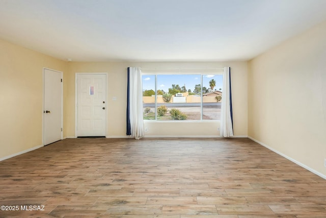 empty room featuring baseboards and wood finished floors