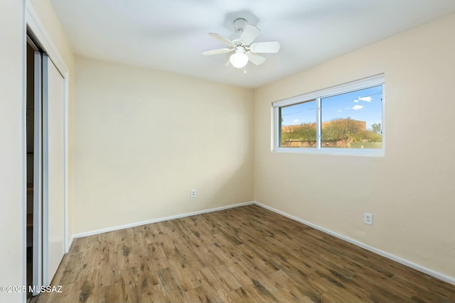 spare room with ceiling fan, wood finished floors, and baseboards