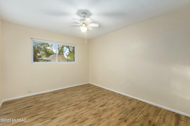 spare room featuring ceiling fan, baseboards, and wood finished floors