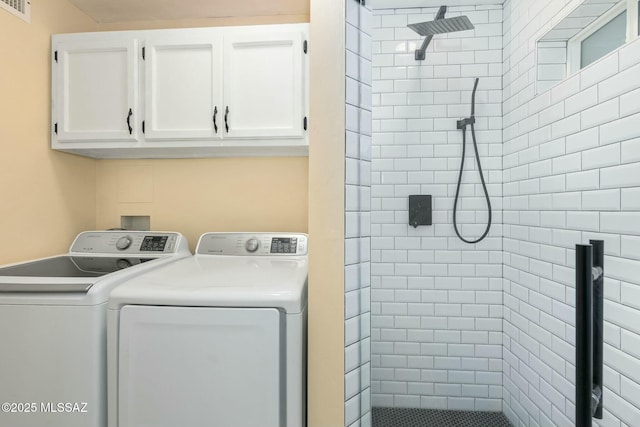 washroom featuring cabinet space, visible vents, and washing machine and clothes dryer