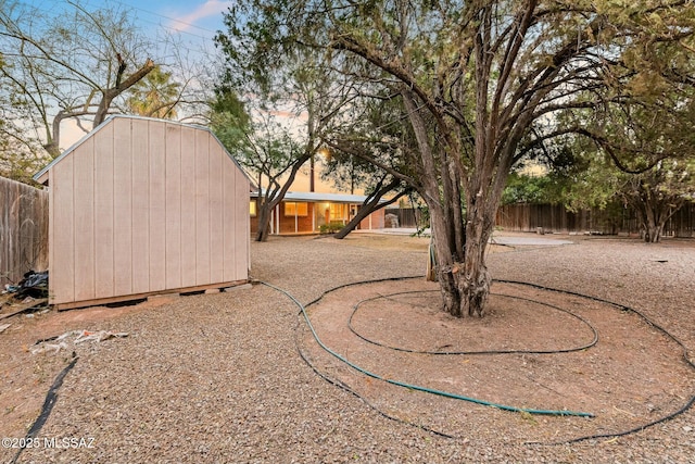 view of yard featuring a fenced backyard, a shed, and an outbuilding