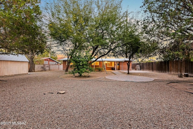 view of yard featuring an outbuilding, a patio area, and fence