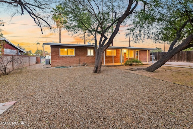 back of property with brick siding and fence