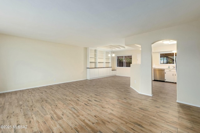 unfurnished living room with light wood-style floors and baseboards