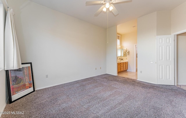 unfurnished bedroom featuring a ceiling fan, light carpet, and ensuite bathroom